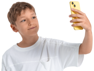 Young boy holding yellow phone for selfie, smiling and looking at screen, photographed in natural style, isolated on white background, concept of modern childhood