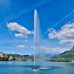 Fountain Jet on Lake Lugano with Scenic Mountain View