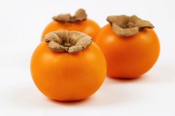 Mature orange persimmon isolated against a white backdrop. Collection of kaki fruits.