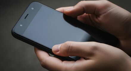 Human hands are shown holding a dark smartphone with a blank screen, ready for interaction. Concept for mobile application, digital communication and user interface design