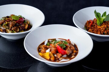 Assortment of Asian Dishes: Kung Pao Chicken, Chili Chicken, and Thai Basil Stir-fry