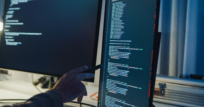 Closeup team adult male engineer collaborate on robotic hand project use AI code solutions machine learn at tech workspace night. Artificial intelligence interface collaboration prototype development.