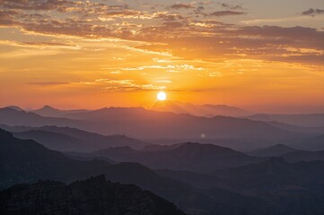 Fototapeta premium Golden sunset sky above shadowy peaks