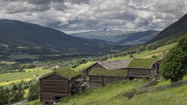 Panorama eines Tals mit alten traditionellen Holzh&uuml;tten und einem weiten Blick auf die Berge, historischer Bauernhof und Pilgerunterkunft Budsjord, Dovre, Pilgerweg Olavsweg oder Olavsleden, Gudbrandsdalen oder Gudbrandstal, Norwegen