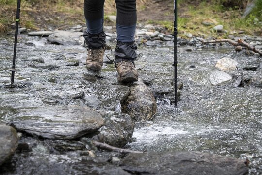 Ein Wanderer &uuml;berquert einen flachen Bach auf Steinen, Pilgeweg Olavsweg, Olavsleden oder Pilgrimsleden, Dovrefjell, Norwegen