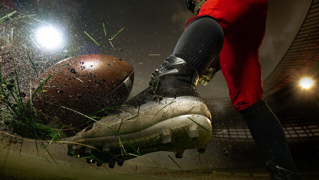 Close-up of American football player foot kicking the ball with grass and dirt flying around. Concept of action, and endurance for advertising, editorial, and sports branding visuals. 3D field