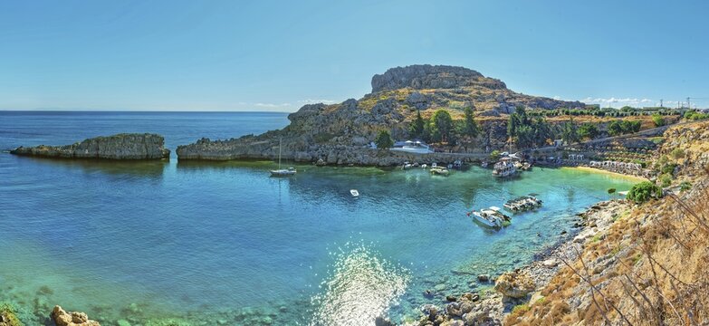 Panoramic view of the calm Paulus Bay of Lindos with turquoise-coloured water, surrounded by cliffs, Acropolis, Lindos, Rhodes, Island, Greece