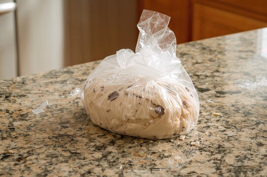 Enclosing cookie dough in plastic wrap before placing it in the fridge to cool down. - Powered by Adobe