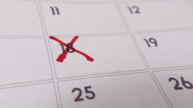 Marking the date number 18, focusing on the number highlighted with a red cross on the calendar. Represents deadlines, reminders, planning, and time management
