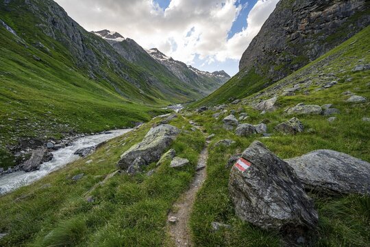 Hiking trail in the Umbaltal valley with Isel mountain stream, glaciated mountain peaks behind, Venediger Group, Hohe Tauern National Park, East Tyrol, Tyrol, Austria