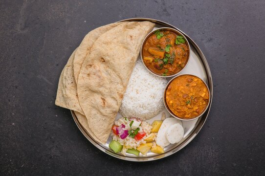 Classic Stainless Steel Lunch Container Featuring Traditional Indian Meal with Flatbread, Dal Tadka, Steamed Rice, Vegetable Curry, Salad, and Pickle