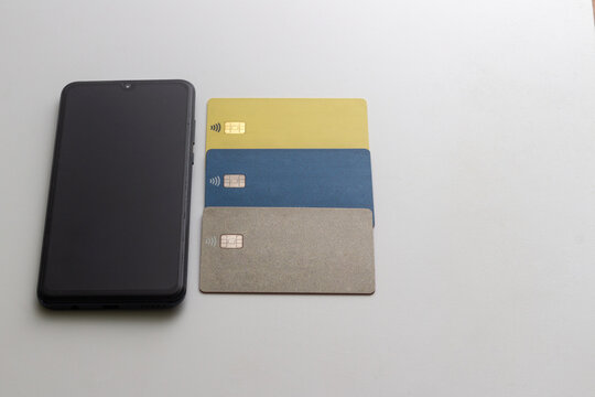 A mobile phone and credit cards are found on the table. For online shopping on Cyber Monday. - Powered by Adobe