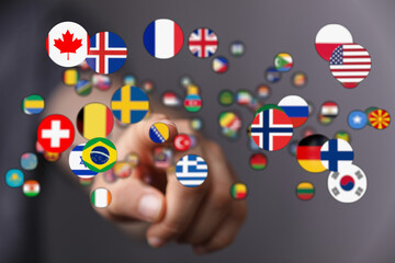 A hand reaching out to touch various national flags, symbolizing international cooperation, connection, and world peace. A visual representation