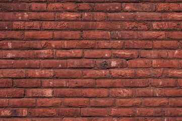 Surface texture of weathered red bricks on an aged wall