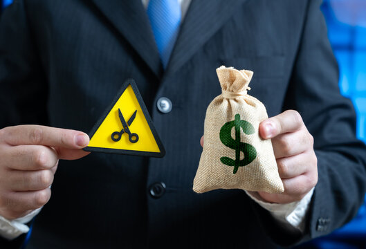 A businessman is forced to cut his budget. Budget sequestration. Saving and cutting costs. Financial crisis, economic slowdown, austerity measures, and expense management.