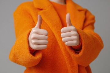Orange coated hand giving a thumbs up