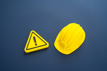 Attention, construction is underway. A construction worker's hard hat and a sign of attention. Repairs and renovations. Concept of industrial safety. Urban planning, renovation projects
