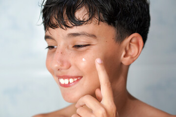 adolescence and skin care. Teenager applying acne treatment