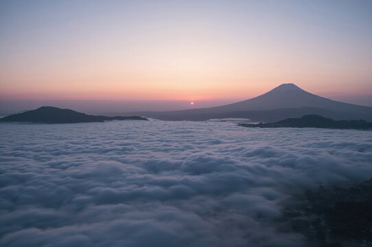 Dawn uncovers cloud-covered mountain summits