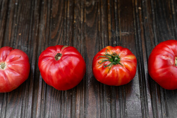 A line of organic, homegrown tomatoes with unique irregular shapes, showcasing their natural and...