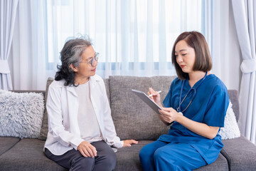 Obraz premium asian senior female giving interview and listening to a visiting nurse who using tablet computer advice elderly woman,concept home care,home health care,health care worker,community outreach