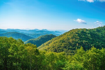 Obraz premium Mountain range under a clear blue sky with smoky haze