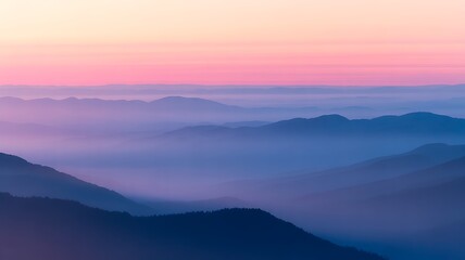 Fototapeta premium Misty mountain range at sunset with pink and blue sky