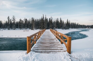 Wooden bridge covered in snow spanning a narrow river in a cold region