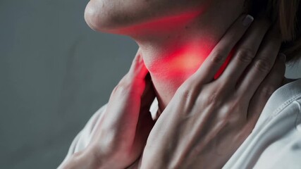 Patient suffering from painful throat, thyroid gland inflammation, tonsillitis or other disease, touching neck with red highlighted pain area
