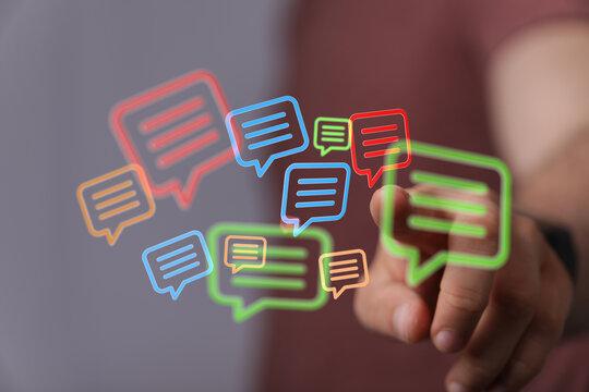 Hand interacting with floating chat boxes for online communication, symbolizing modern connection and digital conversations.