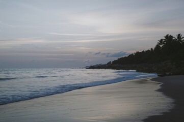 Fototapeta premium Tranquil Shoreline at Twilight with Soft Waves and Muted Sky Tones