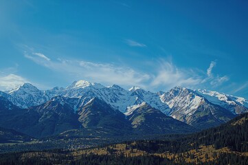 Obraz premium Snow-covered peaks under a clear blue sky, perfect for adventure and nature lovers