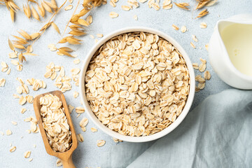 Rolled oats flakes in a wooden bowl with ears.