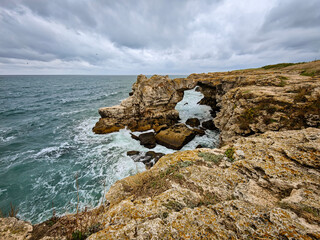Stormy weather in rock arch in Tyulenovo, Bulgaria. Tulenovo stone arc. Dramatic landscape symbolizing nature's power and wild beauty.