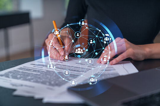 Businesswoman signing contract with social network hologram overlay symbolizing connection and data sharing concept in modern workplace setting.