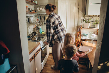 Mother and children preparing food in kitchen