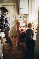 Mother and children spending morning together in kitchen