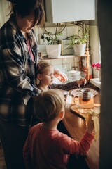 Mother and children making tea in kitchen