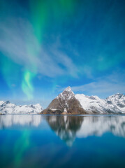 Aurora Borealis in Scandinavia. Norway, Lofoten islands. Northern lights over the mountains. Starry sky. Winter landscape on the north. Photo for background, wallpaper, postcards.