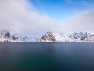 Norway. Nature in fjords. High mountains and reflections. Panoramic view. Clouds over the rocks. Vacation and travel in the winter Norway. Background, wallpaper, postcards.