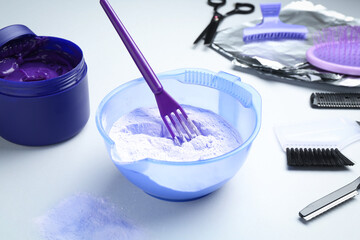 Hair care product for blonde hair and hairdresser's tools on white background, closeup