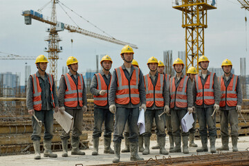 Workers wearing safety helmets at high-rise construction site with cranes, 8K cinematic industrial scene