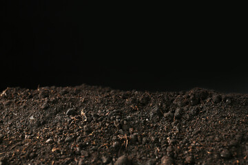 Pile of fresh soil on black background, closeup