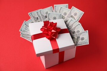 Gift box with dollar banknotes on red background
