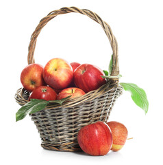 Fresh apples in wicker basket and green leaves isolated on white