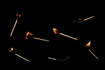 Lit falling match on a black background.