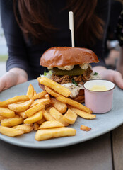Girl Holding Plate With Fried Potatoes And Meat Burger