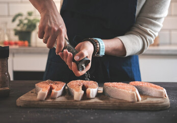 Woman Salting Raw Red Fish Salmon For Cooking