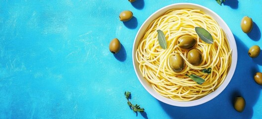 Bowl of spaghetti pasta garnished with olives and fresh herbs on a vibrant blue background- emphasizing flavor and freshness.
