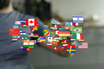 Diverse flags floating around a person's hand symbolizing global connections and international...